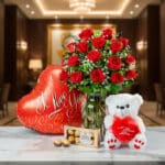 Jarrón Dulce Amor con rosas rojas frescas, un osito de peluche blanco con corazón rojo, chocolates Ferrero Rocher y un globo