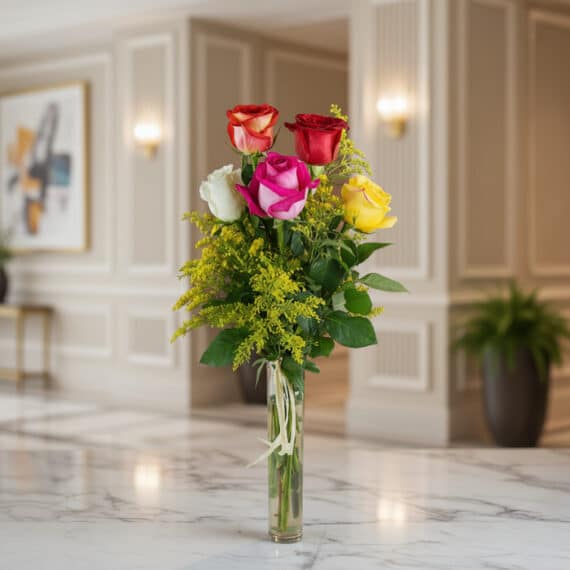 Solitario de rosas multicolor (rojas, blancas, fucsias, amarillas) en un jarrón de cristal, sobre una superficie de mármol, c